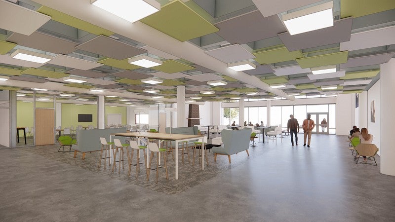 UO Portland Campus Center rendering dining room shows a bright and open space with a variety of seating and tables. The ceiling has a pattern of dropped tiles in tones of gray and light green. The back of the rendering show a wall of windows and doors that open to a patio.